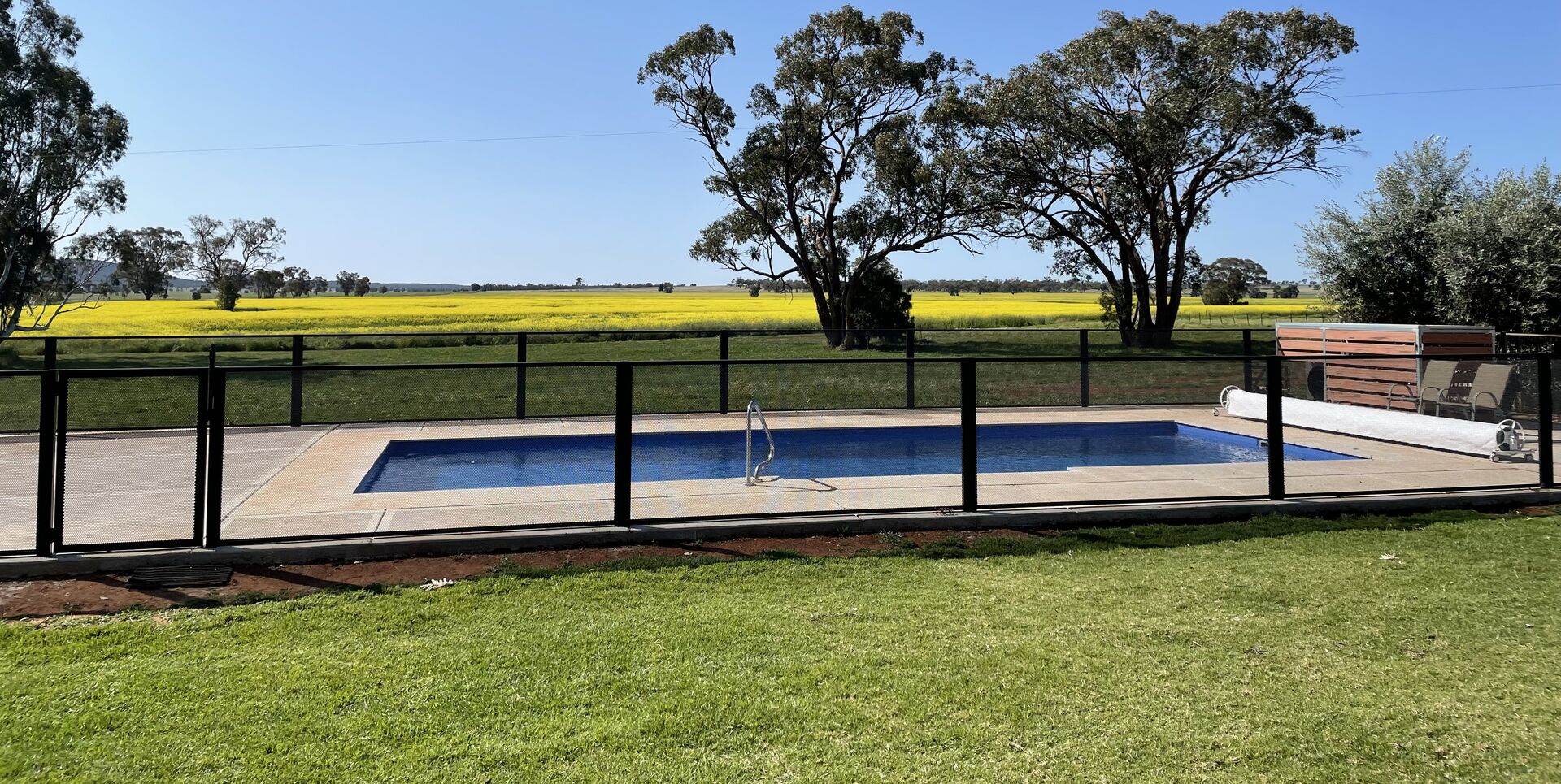 Pure Perf signature perforated pool fencing in Textured Black — the fence disappears into the view